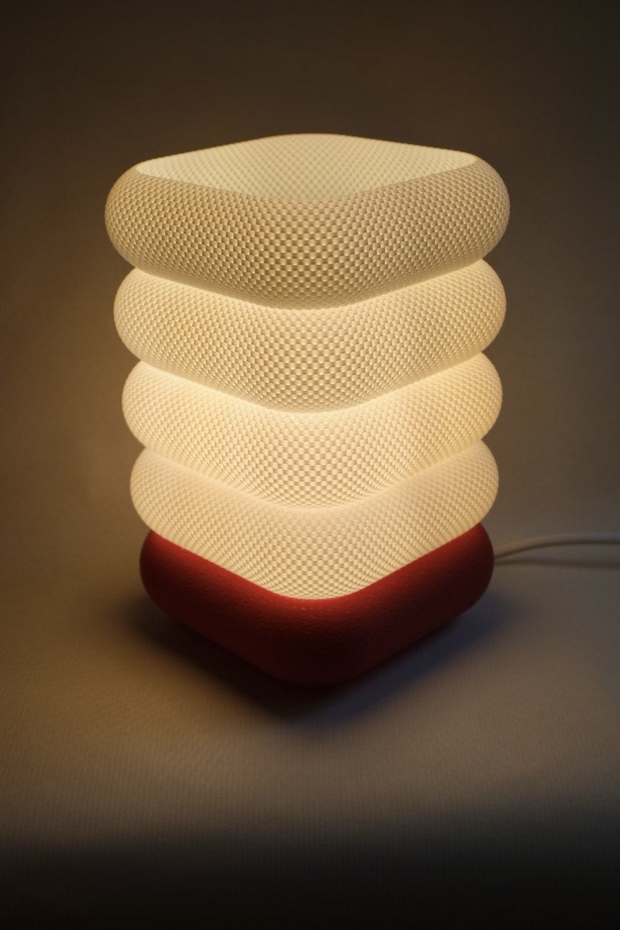 White textured lamp glowing warmly on a red base